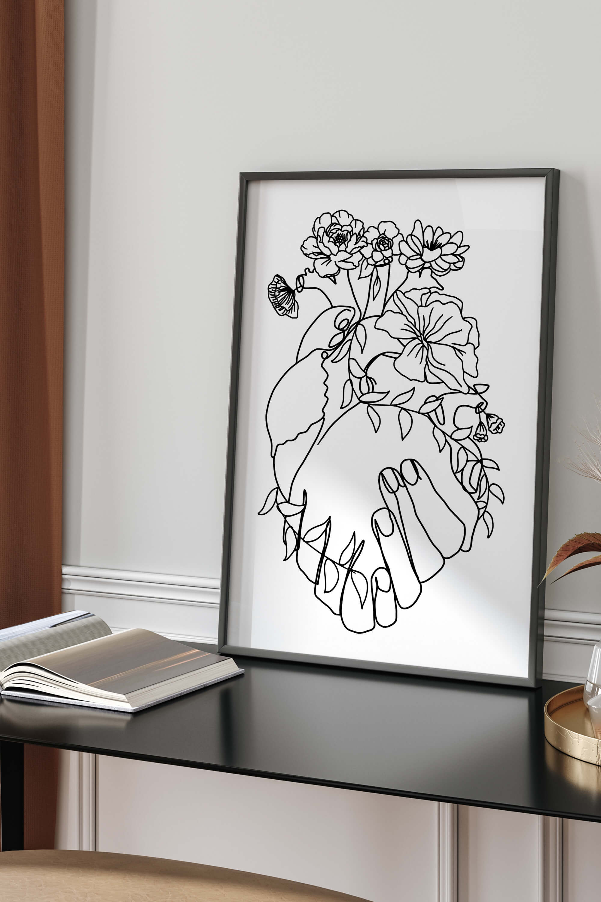 A photo of a framed love line art print that shows the human heart anatomy with aesthetic flower lines. The print is in black and white and combines organic and geometric shapes.