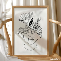 Minimalist woman with floral headpiece art print framed on a white wall.
