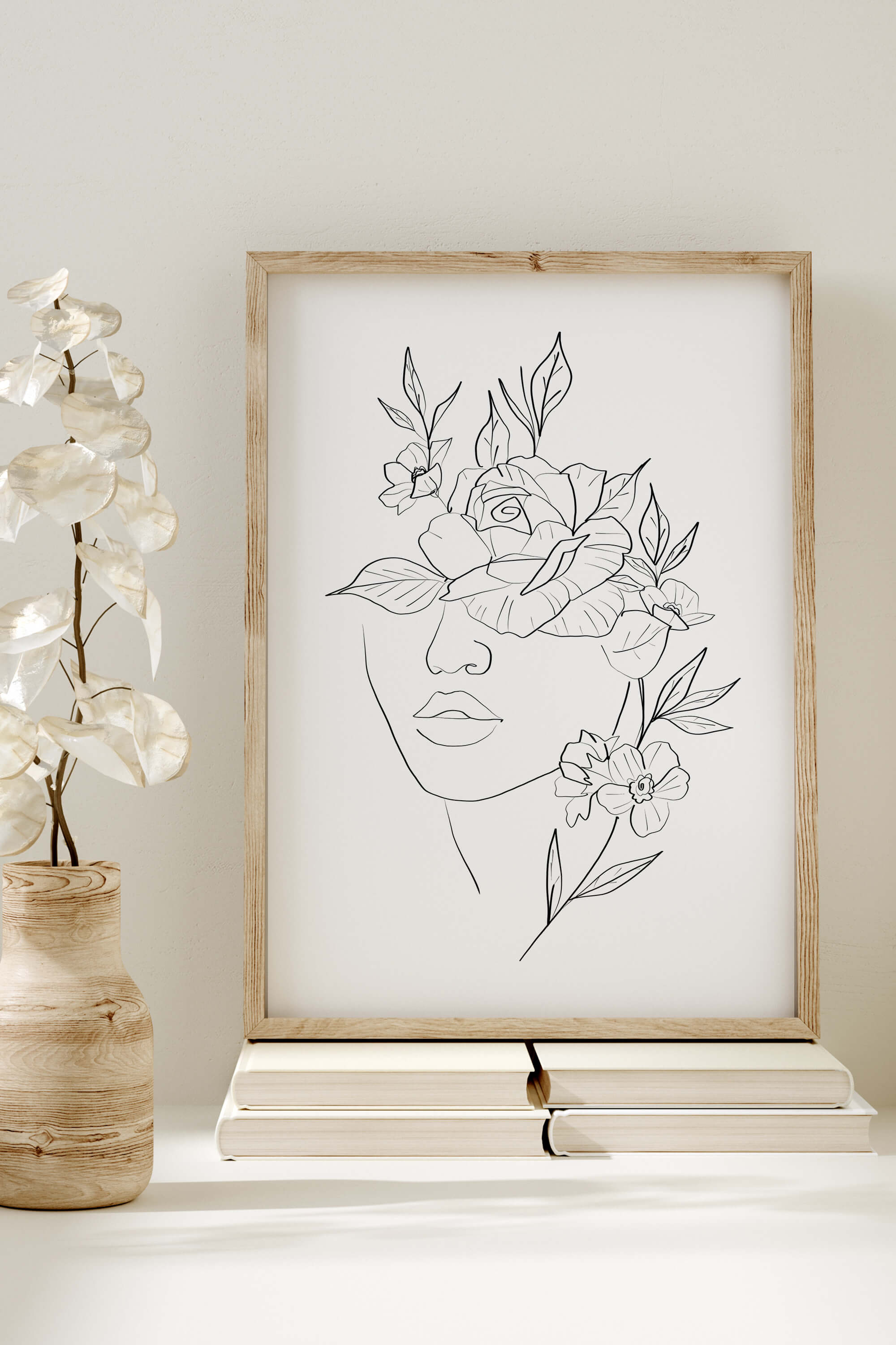 Experience the timeless allure of monochrome magic with this art print, featuring a woman's face surrounded by floral elements, creating a harmonious blend of beauty and simplicity.