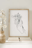 Mesmerizing home decor print with delicate lines, portraying a woman holding a bouquet. Elevate your space with this unique blend of nature-inspired charm and intricate design.