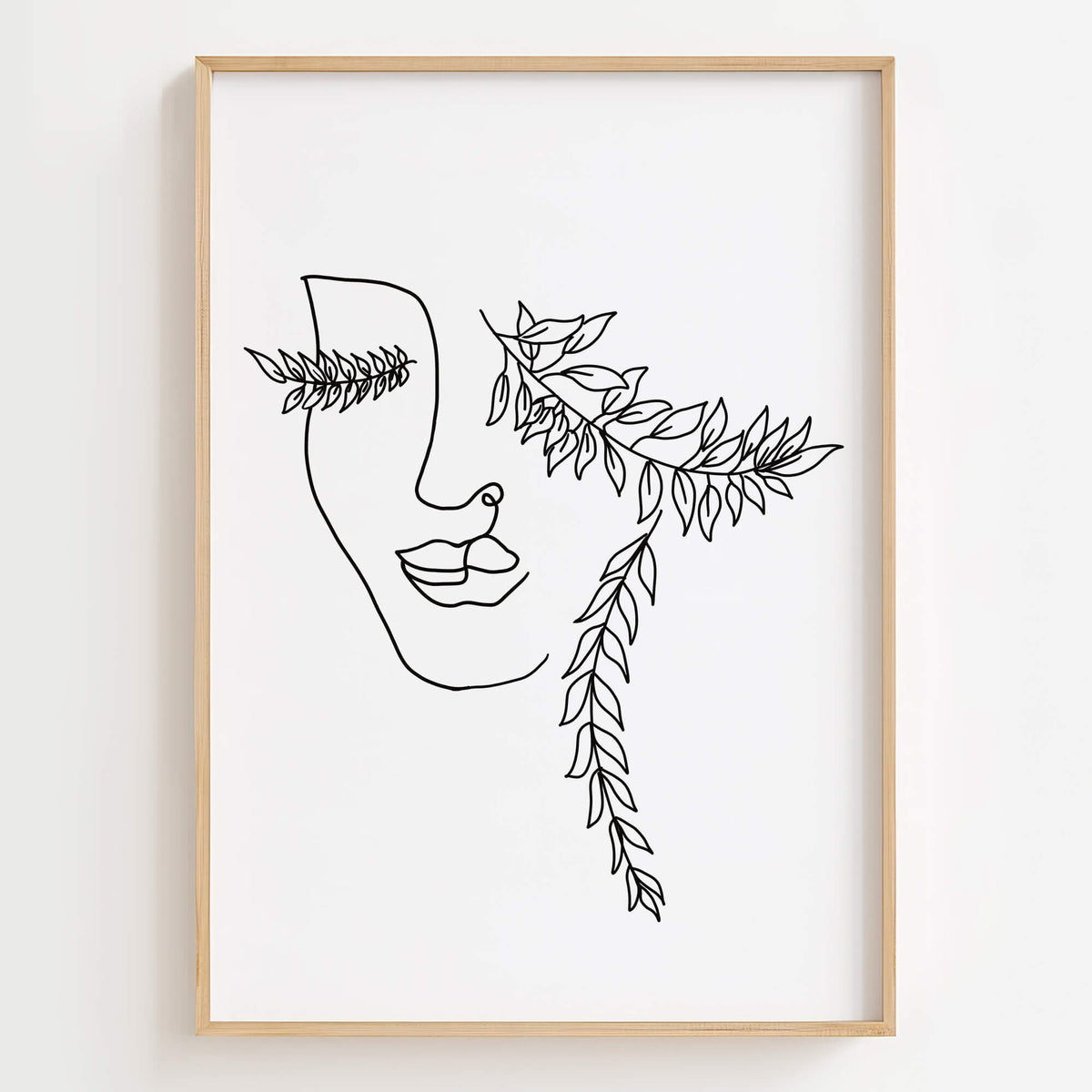 Minimalist line art print of a woman's face adorned with botanical leaves.
