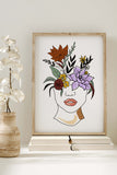 Nature and style wall decor showcasing a line art print of a woman's face framed by flowers.