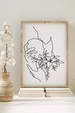 Botanical floral wall art print, transforming spaces into a sanctuary of peace. Delicate dance of botanical elements intertwining with the gentle curves of a woman. A harmonious blend of art and nature, bringing elegance to your surroundings.