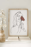 Timeless elegance art print of a woman with a rose displayed on a wall, complementing modern home decor.